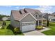 Two-story house with gray siding, white garage door, and landscaped yard at 135 Glenfield Ln, Burlington, NC 27215