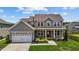 Two-story house with gray siding, white garage door, and landscaped front yard at 135 Glenfield Ln, Burlington, NC 27215