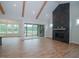 Open living area with hardwood floors, exposed beams, fireplace and access to a screened porch at 16 Autumn Breeze Ct, Angier, NC 27501