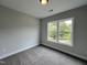 Well-lit bedroom featuring grey carpet and a large window at 156 S Mistflower St, Clayton, NC 27520