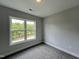 Bright bedroom with grey carpet and a view of trees at 156 S Mistflower St, Clayton, NC 27520