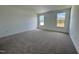 Well-lit bedroom with neutral carpeting and two windows at 1220 Porters Call Dr, Wendell, NC 27591