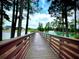 Scenic boardwalk path over serene community lake with fountain at 1220 Porters Call Dr, Wendell, NC 27591