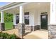 Covered front porch with stone columns and a dark-colored front door at 81 Eagle Crest Ct # Apex Craftsman, Lillington, NC 27546