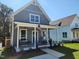 Charming gray farmhouse with a covered porch and American flag at 199 N Smith St, Clayton, NC 27520