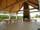 Covered pavilion with fireplace and picnic tables near pool at 13 Blackhorn Ct, Pittsboro, NC 27312