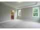 Main bedroom with carpet, windows, and en-suite bathroom access at 6020 Scalybark Road, Durham, NC 27712