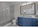 Modern bathroom with blue vanity, gray tile shower, and glass enclosure at 2646 Marchmont St, Raleigh, NC 27608