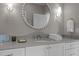 Modern bathroom with white vanity, gray countertop, and a round mirror at 2646 Marchmont St, Raleigh, NC 27608