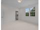 Bright bedroom with carpet flooring, large windows, and ensuite bathroom access at 2646 Marchmont St, Raleigh, NC 27608
