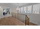 Light-filled upper hallway with hardwood floors, chandelier, and view into home office at 2646 Marchmont St, Raleigh, NC 27608