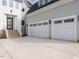 Three-car garage with white doors and gray exterior at 1245 Azalea Garden Circle, Raleigh, NC 27603