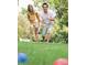 A couple enjoys a game of bocce ball on a lush green lawn within the community's recreational area at 3911 Willow Gate Way, Raleigh, NC 27604