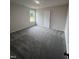 Well-lit bedroom with carpet and large window at 32 Oakfield Trace Dr, Four Oaks, NC 27524