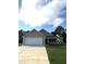Newly built beige house with a white garage door and landscaping at 32 Oakfield Trace Dr, Four Oaks, NC 27524