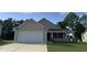 Beige house with white garage door and stone accents at 32 Oakfield Trace Dr, Four Oaks, NC 27524