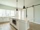 White kitchen with island, stainless steel appliances, and a unique barn door at 1140 Cottonsprings Dr, Wendell, NC 27591