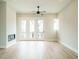Spacious living room featuring hardwood floors, a fireplace, and French doors leading to a balcony at 1140 Cottonsprings Dr, Wendell, NC 27591