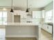 Modern kitchen with white cabinets, quartz countertops and island at 1140 Cottonsprings Dr, Wendell, NC 27591
