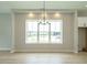 Bright dining room with hardwood floors, a large window and chandelier at 1140 Cottonsprings Dr, Wendell, NC 27591