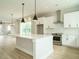 Modern kitchen with white cabinets, large island, and stainless steel appliances at 1140 Cottonsprings Dr, Wendell, NC 27591