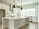 Modern kitchen with white cabinets, quartz countertops, and stainless steel appliances at 1140 Cottonsprings Dr, Wendell, NC 27591