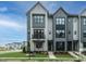Modern three-story townhome with gray siding, black windows, and a front porch at 1140 Cottonsprings Dr, Wendell, NC 27591