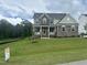 Two-story house with stone accents and a large front yard at 155 Streamside Dr, Angier, NC 27501