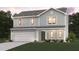 Two-story house with light green siding and a two-car garage at 5767 Waxwing Dr, Snow Camp, NC 27349