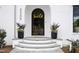 Elegant front entrance with arched doorway, stone steps, and landscaping at 3300 Founding Place, Raleigh, NC 27612