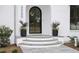 Elegant front entrance with arched doorway, stone steps, and landscaping at 3300 Founding Place, Raleigh, NC 27612