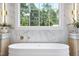 Bright bathroom with a soaking tub and large window at 3300 Founding Place, Raleigh, NC 27612
