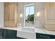 Bright laundry room with farmhouse sink, marble countertops, and shaker cabinets at 3300 Founding Place, Raleigh, NC 27612