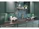 Butler's pantry with dark green cabinets and gold accents at 3300 Founding Place, Raleigh, NC 27612