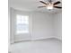 Bright, empty bedroom with large window, ceiling fan, and gray carpet at 7412 Prato Ct, Wendell, NC 27591