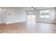 Living room with wood-look flooring, sliding glass door, and large windows at 7412 Prato Ct, Wendell, NC 27591