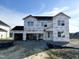 Two-story new construction home with gray siding, white trim, and a three-car garage at 674 Barbour Farm Ln, Four Oaks, NC 27524