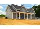 Two-story gray house with white trim, front porch, and landscaping at 6030 Preacher Hayes Rd, Mebane, NC 27302