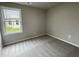 Well-lit bedroom with neutral carpeting and a window at 83 Oakfield Trace Dr, Four Oaks, NC 27524