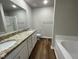 Double vanity bathroom with granite countertops and a garden tub at 83 Oakfield Trace Dr, Four Oaks, NC 27524