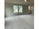Spacious living room featuring neutral carpeting and large windows at 83 Oakfield Trace Dr, Four Oaks, NC 27524