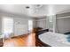 Spacious bedroom with hardwood floors, a ceiling fan, and a fireplace at 8401 Mitchell Mill Rd, Zebulon, NC 27597