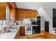 Kitchen features wood cabinets, white appliances, and access to adjacent living space at 8401 Mitchell Mill Rd, Zebulon, NC 27597