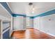 Spacious bedroom with hardwood floors, built-in shelving and ceiling fan at 8401 Mitchell Mill Rd, Zebulon, NC 27597