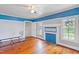 Bedroom with hardwood floors, ceiling fan, fireplace, and blue walls at 8401 Mitchell Mill Rd, Zebulon, NC 27597