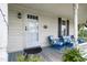 Inviting front porch with blue chairs and a white door at 8401 Mitchell Mill Rd, Zebulon, NC 27597
