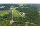 Aerial view showing home, barns, and surrounding green space at 8401 Mitchell Mill Rd, Zebulon, NC 27597