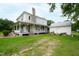 Two-story farmhouse with wraparound porch and stone chimney at 8401 Mitchell Mill Rd, Zebulon, NC 27597