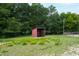 Red horse shelter in a grassy paddock with horses grazing nearby at 8401 Mitchell Mill Rd, Zebulon, NC 27597