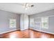 Bright bedroom with hardwood floors, ceiling fan, and built-in closet at 8401 Mitchell Mill Rd, Zebulon, NC 27597